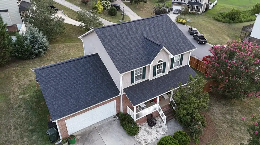 Drone view of a two-story home with a new charcoal shingle roof at the end of a cul-de-sac