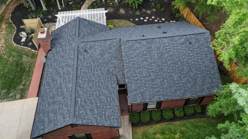 Drone view of a finished charcoal shingle roof on a brick ranch home in Matthews, NC