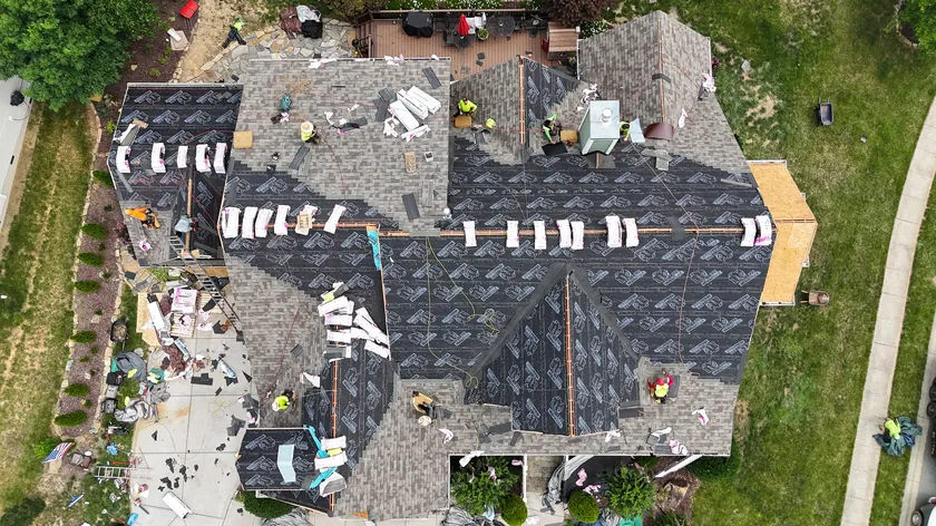 Drone view straight down on our crew replacing a large roof in Locust, NC, half in new underlayment and half in old shingles
