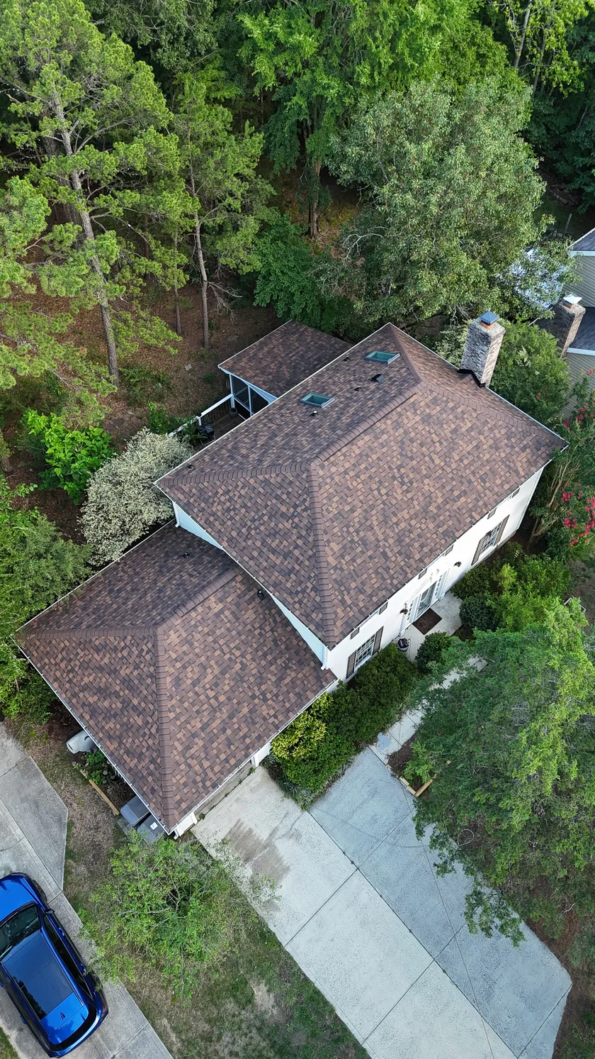 Drone view looking down on a finished brown shingle hip roof with two skylights in Ballantyne, Charlotte