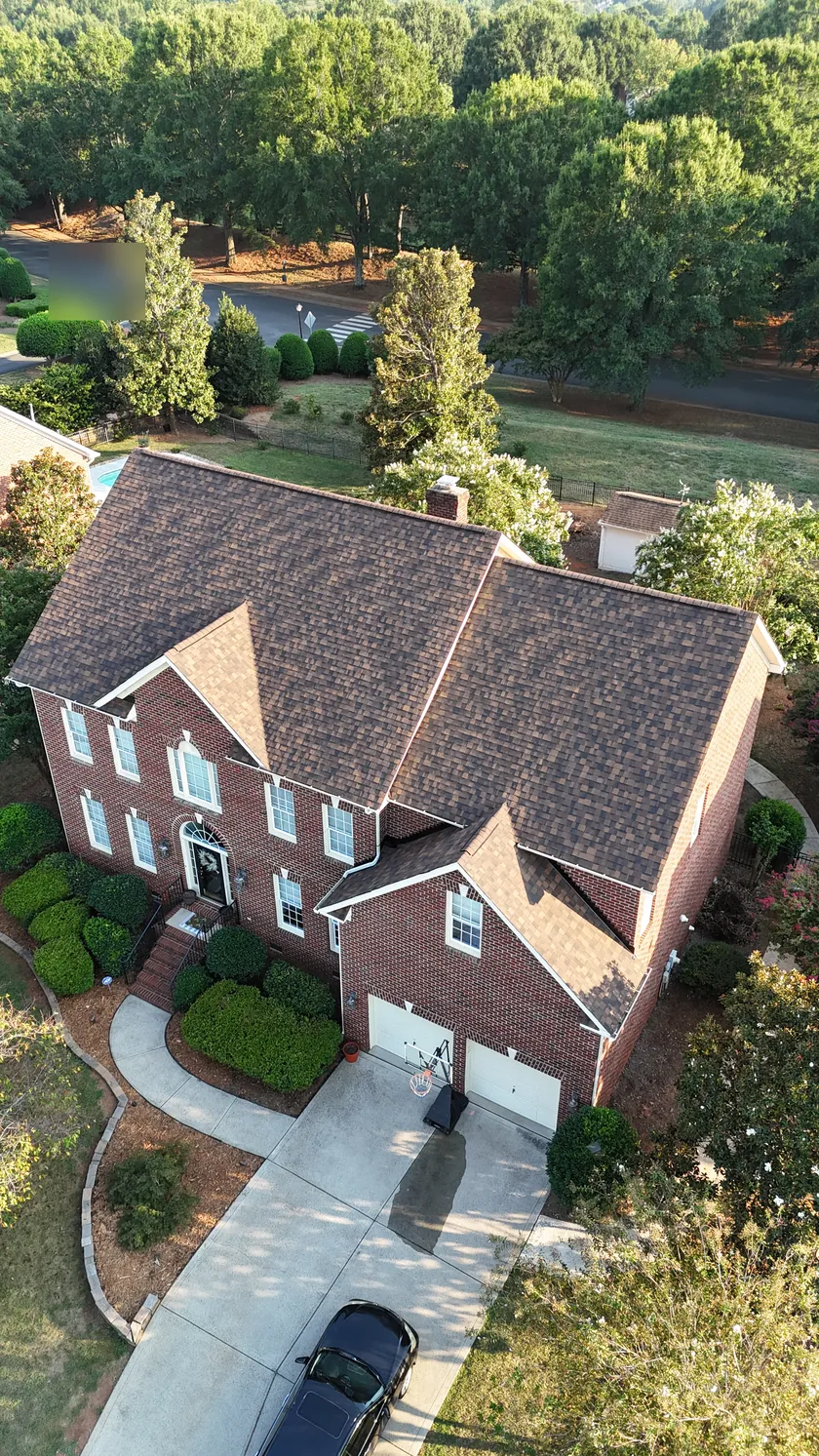 Drone view of a finished brown shingle roof on a two-story brick home in Union County, NC