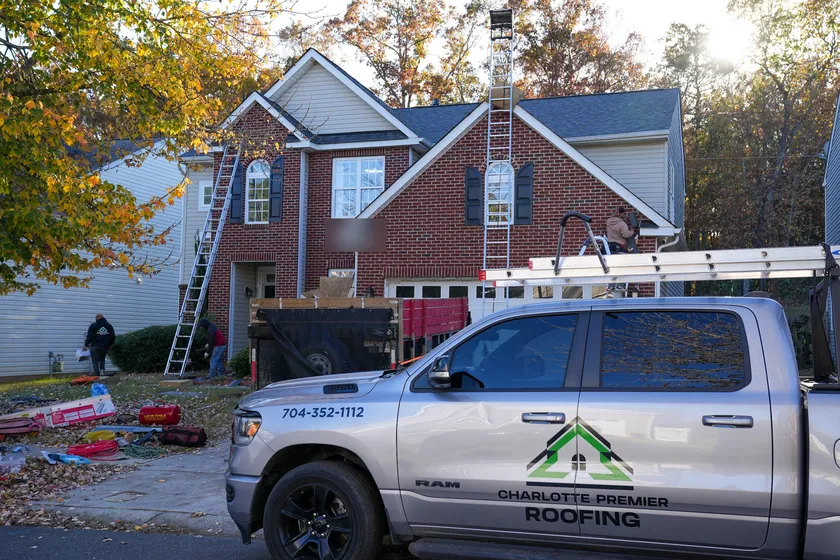 Charlotte Premier Roofing truck parked out front while our crew works on a brick home in Ballantyne
