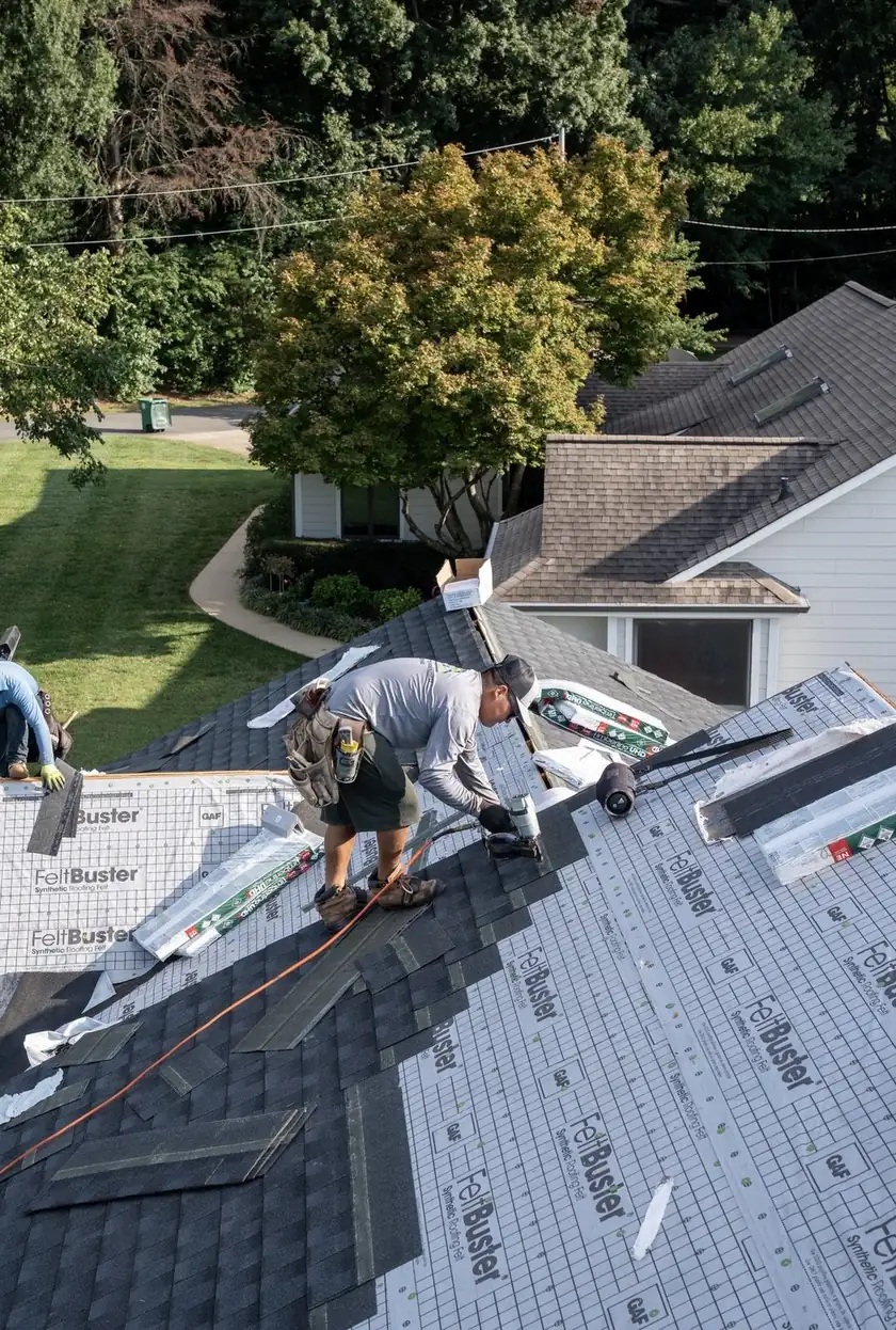 Charlotte Premier Roofing roofer nailing new shingles over synthetic underlayment