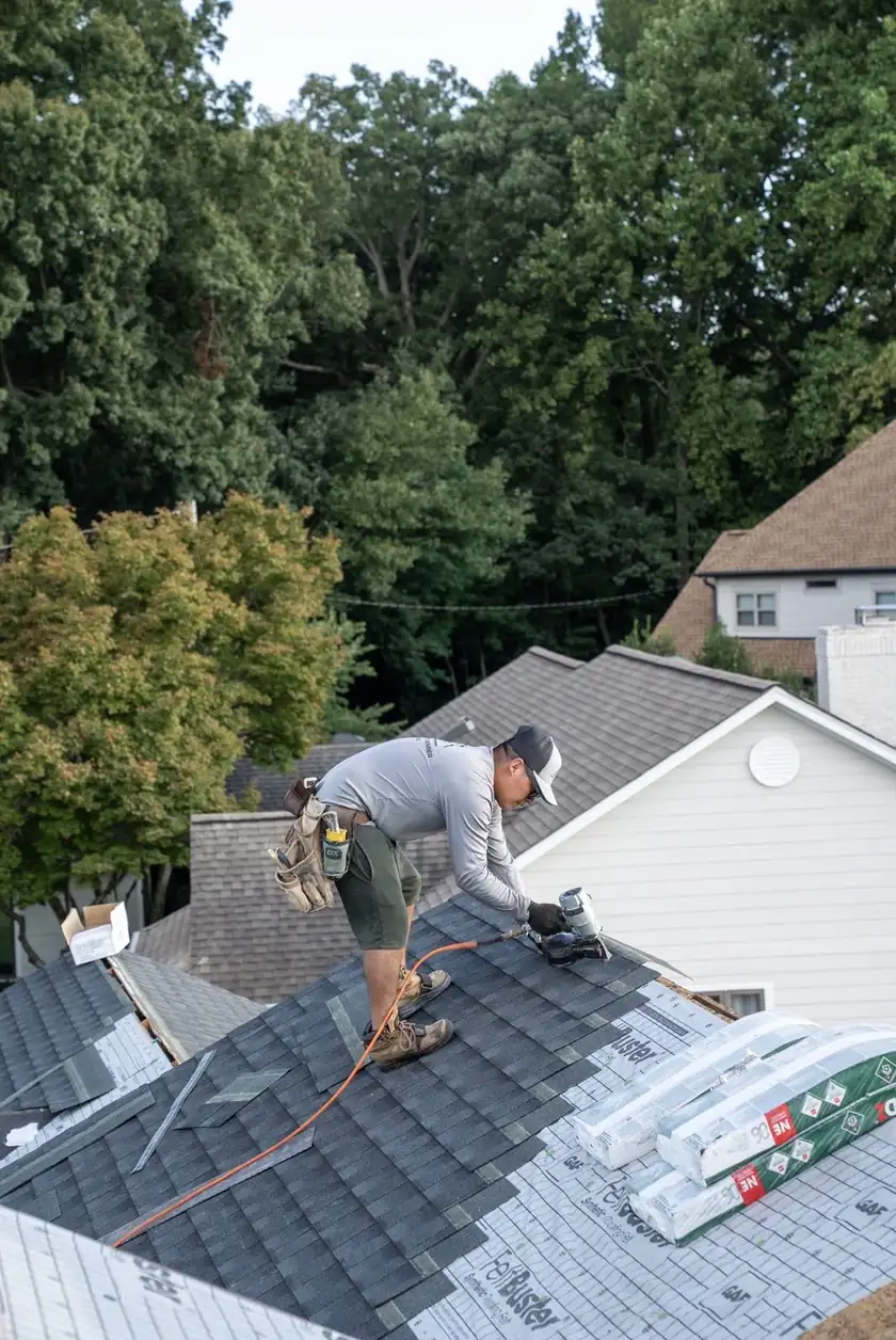 Charlotte Premier Roofing roofer nailing architectural shingles over synthetic underlayment in Weddington, NC