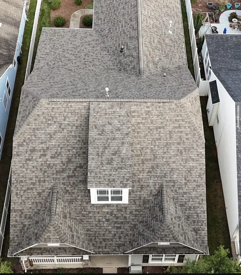 Aerial view of a finished shingle roof between two neighboring homes